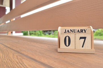 January 7, Number cube with wooden balcony background.