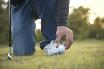 Hand of asian golfer holding golf on lawn,thailand people play golf