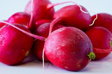 Red radish with root on a white background
Close-up of red radish with root on a white background. Reflection from a glossy table.