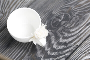 Handmade cup decorated with polymer clay roses. Jewelry made of white polymer clay.