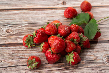 Fresh ripe perfect strawberry on wooden background. Fresh strawberry as texture background. Natural food backdrop with red berries. Strawberries sale in a food market in summer.