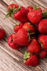 Fresh ripe perfect strawberry on wooden background. Fresh strawberry as texture background. Natural food backdrop with red berries. Strawberries sale in a food market in summer.