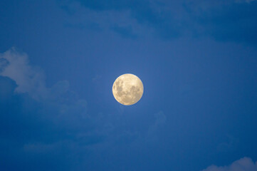 moon surrounded by clouds announcing an illuminated night