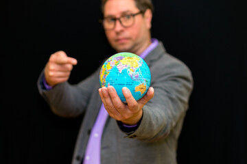 Close up of businessman holding digital globe in palm and shows at globe global business communications concept.