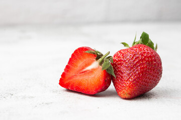 Fresh ripe perfect pieces strawberry on white marble background. Fresh strawberry isolated. Natural food backdrop with red berries. Strawberries sale in a food market in summer.