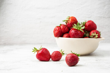 Fresh strawberries in a bowl on marble white table. Fresh nice strawberries. Strawberry field on fruit farm. Heap of Red strewberry on plate close up. Juice strawberry. Strawberry field on fruit farm.