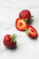 Fresh ripe perfect pieces strawberry on white marble background. Fresh strawberry as texture background. Natural food backdrop with red berries. Strawberries sale in a food market in summer.