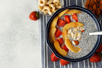 Bowl of chia poudding with pieces of apricots and strawberry
