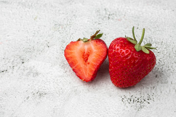 Fresh ripe perfect pieces strawberry on white marble background. Fresh strawberry as texture background. Natural food backdrop with red berries. Strawberries sale in a food market in summer.