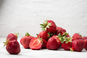 Fresh ripe perfect pieces strawberry on white marble background. Fresh strawberry as texture background. Natural food backdrop with red berries. Strawberries sale in a food market in summer.
