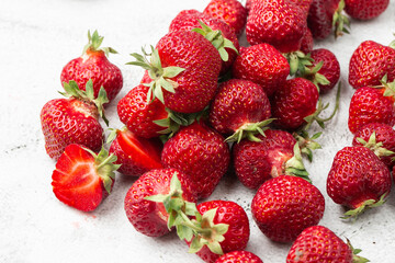 Fresh ripe perfect strawberry on white marble background. Fresh strawberry as texture background. Natural food backdrop with red berries. Strawberries sale in a food market in summer.