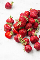 Fresh ripe perfect strawberry on white marble background. Fresh strawberry as texture background. Natural food backdrop with red berries. Strawberries sale in a food market in summer.