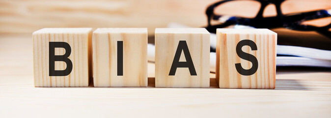 The word BIAS, spelt with wooden letter tiles over a white background.
