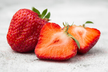 Fresh ripe perfect pieces strawberry on white marble background. Fresh strawberry as texture background. Natural food backdrop with red berries. Strawberries sale in a food market in summer.