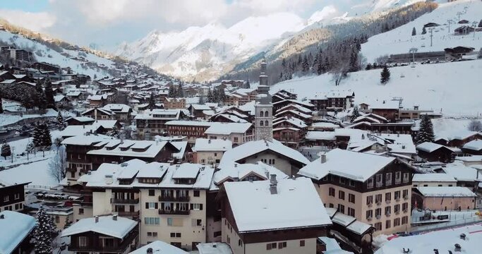 Aerial view of french ski station La Cluzat with its mountains, snowy peaks, chalets and ski slopes, famous ski resort in the Alps, France