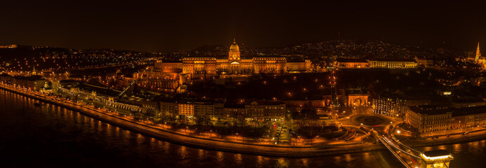 Fototapeta premium Panoramic aerial drone shot of Buda castle on Buda Hill in Budapest night with city lights on