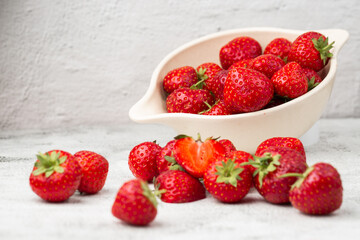 Fresh strawberries in a bowl on marble white table. Fresh nice strawberries. Strawberry field on fruit farm. Heap of Red strewberry on plate close up. Juice strawberry. Strawberry field on fruit farm.