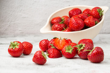Fresh strawberries in a bowl on marble white table. Fresh nice strawberries. Strawberry field on fruit farm. Heap of Red strewberry on plate close up. Juice strawberry. Strawberry field on fruit farm.