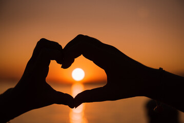 At sunset a heart from two hands