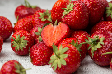 Fresh ripe perfect strawberry on white marble background. Fresh strawberry as texture background. Natural food backdrop with red berries. Strawberries sale in a food market in summer.