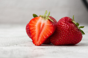 Fresh ripe perfect pieces strawberry on white marble background. Fresh strawberry as texture background. Natural food backdrop with red berries. Strawberries sale in a food market in summer.
