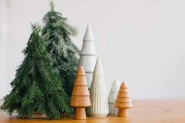 Christmas trees on rustic wooden table. Festive modern decor, zero waste. Happy holidays. Miniature...