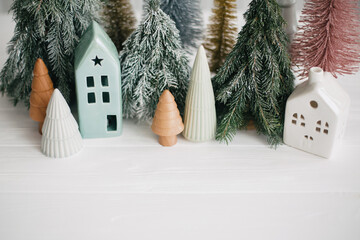 Happy holidays. Miniature cozy village, ceramic houses, wooden and handmade christmas trees....