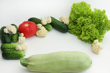 fresh vegetables close-up tomatoes, cucumbers, lettuce, cauliflower, zucchini lie in a circle in the center of the vegetables sign with advertising or text