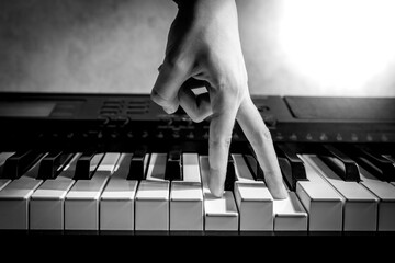 musician's fingers on piano keys, blues and jazz, learning to play a musical instrument, black and...