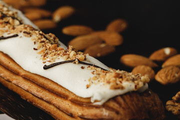 Eclair cake on dark wooden board on black table