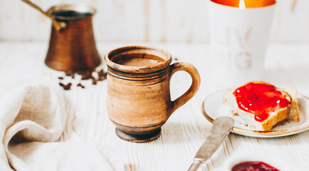 Coffee, toast and jam on a white wooden table
