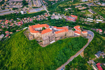 Aerial view of medieval castle Palanok, Mukachevo (Munkacs), Transcarpathia (Zakarpattia), Ukraine. Summer landscape with old architecture, green trees and town, outdoor travel background