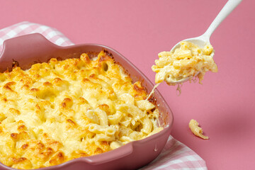 Mac and cheese baked in bechamel sauce. Macaroni with cheese on a spoon.