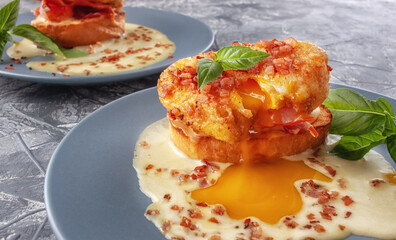 Eggs Benedict on toasted muffins with ham and sauce