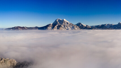 Luftaufnahme über dem Nebel mit Winterlichem Berg
