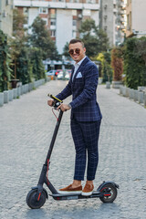 Young bussinesman with electric scooter posing during work break.