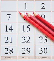 calendar and three red pencils near the first date