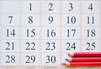 calendar and three red pencils near the last date