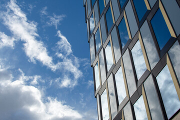 Modern architecture with reflection of clouds and blue sky