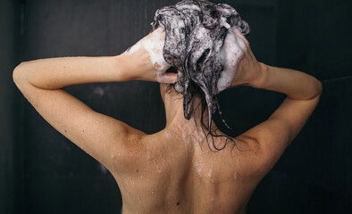 Young pretty woman take shower with shampoo