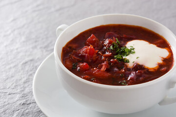 Traditional Ukrainian Russian borsch. Beetroot soup on gray background	