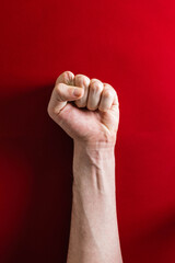 Hand with clenched fist on red background