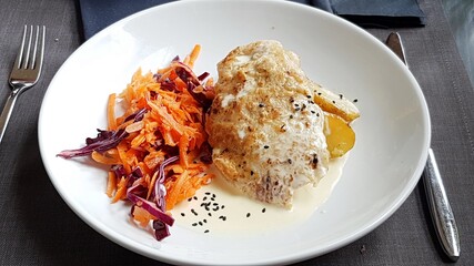 Piece of pork fried in a pan and potatoes with a salad of carrots and beets