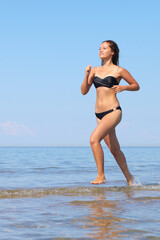 Fototapeta premium Woman in bikini run on beach