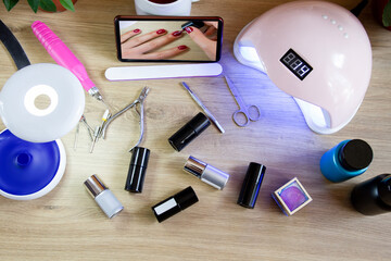 Tools for manicure. A set of varnishes, a mobile phone, an ultraviolet lamp. Manicure at home.