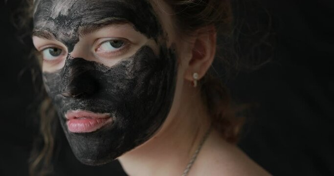 Beautiful girl with care mask on skin turns head on the camera 