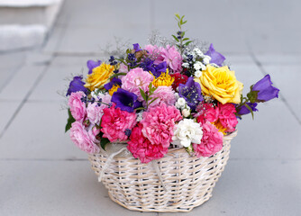 Bright beautiful bouquet of roses  in a straw basket. Holiday concept.
