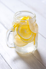 Water with lemon slices in a glass glass. Detoxifying vitamin drink. Vitamin C. Dietary nutrition, healthy lifestyle. The concept of health.