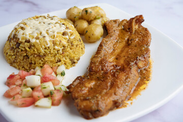 Rice with lentils, baked pork ribs, boiled potatoes, and tomato cucumber salad. Arroz moro.