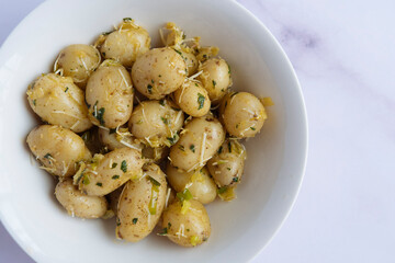 Delicious potatoes sprinkled with parsley and parmesan cheese on white plate on table